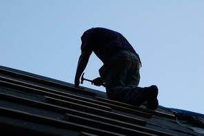silhouette man working on roof